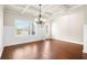 Bright dining room features wood floors, wainscoting, a modern chandelier, and a large window at 100 Nemoura Ct, Fairburn, GA 30213