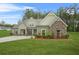 Charming single-story home featuring a mix of stone and green siding, complemented by a lush green lawn at 100 Nemoura Ct, Fairburn, GA 30213