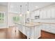 Spacious kitchen with white cabinets, a large center island, granite countertops, and stainless appliances at 100 Nemoura Ct, Fairburn, GA 30213