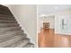 View of a carpeted staircase leading into an open living space with a fireplace and access to the outdoors at 100 Nemoura Ct, Fairburn, GA 30213