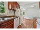 Functional kitchen featuring wood cabinets, white appliances, and a bright window overlooking the yard at 2015 Twelve Oaks Nw Cir, Kennesaw, GA 30144