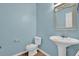 Cozy bathroom featuring a pedestal sink and a toilet, perfect for a compact space at 7293 Bridlewood Ct, Jonesboro, GA 30236