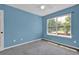 Bright bedroom featuring a window offering a pleasant view and light blue colored walls at 7293 Bridlewood Ct, Jonesboro, GA 30236