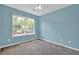 Inviting bedroom with soft blue walls, carpet flooring, and a large window view of the outside at 7293 Bridlewood Ct, Jonesboro, GA 30236