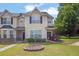 Inviting townhome featuring a well-manicured lawn and neutral-toned facade with dark shutters at 7293 Bridlewood Ct, Jonesboro, GA 30236