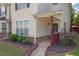 Cozy townhome highlighting a tidy lawn, blooming flowers, and a covered entrance at 7293 Bridlewood Ct, Jonesboro, GA 30236