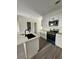 Modern kitchen featuring white cabinets, stainless steel appliances, and a center island with a black sink at 4011 Redan Rd # 9, Stone Mountain, GA 30083