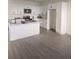 Bright kitchen features white cabinets, stainless steel appliances, a center island, and gray wood-look flooring at 4011 Redan Rd # 9, Stone Mountain, GA 30083