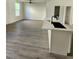 An open-concept space with new gray floors, a kitchen island with a black sink, and a full view of the living room at 4011 Redan Rd # 9, Stone Mountain, GA 30083