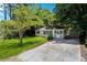 Charming home featuring a well-manicured lawn, mature trees, and a welcoming screened front porch at 4742 West Dr, Forest Park, GA 30297