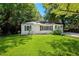 A charming one-story home with green shutters and lush green lawn, surrounded by mature trees at 4742 West Dr, Forest Park, GA 30297