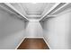 An empty walk-in closet with overhead beams and hardwood floors presents an opportunity for organized storage at 6851 Ne Roswell Rd # C4, Atlanta, GA 30328