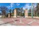 A charming entrance to Abernathy Greenway is constructed with brick pillars and an iron gate at 6851 Ne Roswell Rd # C4, Atlanta, GA 30328
