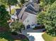 Aerial view of the home showing its well-manicured lawn, driveway, and proximity to mature trees and the neighborhood at 10635 Sugar Crest Ave, Johns Creek, GA 30097