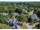 Aerial view of a neighborhood showcasing well-maintained homes, lush trees, and winding streets at 10635 Sugar Crest Ave, Johns Creek, GA 30097