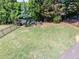 Large backyard with green grass, an iron fence, and a fire pit seating area at 10635 Sugar Crest Ave, Johns Creek, GA 30097