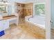 Bathroom features a soaking tub, walk-in shower with tile surround, and wood countertop vanity at 10635 Sugar Crest Ave, Johns Creek, GA 30097