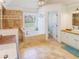 Bright bathroom featuring a soaking tub, tiled floor, and a wood countertop vanity with a sink at 10635 Sugar Crest Ave, Johns Creek, GA 30097