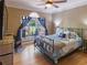 Bright bedroom with hardwood floors, a ceiling fan, and a stylish metal frame bed at 10635 Sugar Crest Ave, Johns Creek, GA 30097