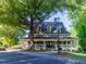 Charming clubhouse with inviting wrap-around porch is set among mature trees at 10635 Sugar Crest Ave, Johns Creek, GA 30097