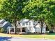 Charming two-story home with a manicured lawn and mature trees creating a picturesque curb appeal at 10635 Sugar Crest Ave, Johns Creek, GA 30097