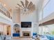 Spacious living room with fireplace, stone surround, built-in shelving, and two-story windows at 10635 Sugar Crest Ave, Johns Creek, GA 30097