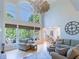 Sun-filled living room featuring soaring ceilings, large windows, and comfortable seating arrangement at 10635 Sugar Crest Ave, Johns Creek, GA 30097