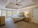 Main bedroom with tray ceilings, plush carpet, neutral walls and ensuite bathroom at 10635 Sugar Crest Ave, Johns Creek, GA 30097