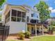 Spacious home showcasing the rear elevation, deck, covered porch and lush backyard at 10635 Sugar Crest Ave, Johns Creek, GA 30097