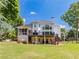 Rear view of a two-story home featuring a deck, covered porch, and large backyard at 10635 Sugar Crest Ave, Johns Creek, GA 30097