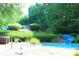 Fun waterslide that empties into a refreshing splash pool surrounded by lush greenery at 10635 Sugar Crest Ave, Johns Creek, GA 30097