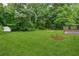 Beautifully maintained backyard with lush grass, a shed, mature trees, and an outdoor deck for entertaining at 2040 Sunrise Cir, Cumming, GA 30040