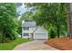 Beautiful two-story home surrounded by lush green trees, featuring a brick pathway and an attached garage at 2040 Sunrise Cir, Cumming, GA 30040