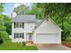 Charming two-story home with a well-manicured lawn, white siding, and an attached two-car garage at 2040 Sunrise Cir, Cumming, GA 30040