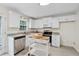 Bright kitchen features stainless steel appliances, white cabinets, and an island with a butcher block countertop at 2040 Sunrise Cir, Cumming, GA 30040