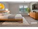 Bright bedroom with large window, plant, and staged with modern furniture at 1477 Harlequin Way, Stockbridge, GA 30281