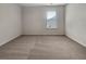 Empty, carpeted bedroom with one window letting in natural light at 1477 Harlequin Way, Stockbridge, GA 30281