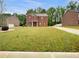 Charming two-story brick home with a lush green lawn and beautiful landscaping in a quiet, residential neighborhood at 1477 Harlequin Way, Stockbridge, GA 30281