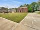 Charming two-story brick home with a lush green lawn and long driveway in a quiet, residential neighborhood at 1477 Harlequin Way, Stockbridge, GA 30281