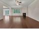Open-concept living room with fireplace, hardwood floors, and abundant natural light from large windows and glass doors at 1477 Harlequin Way, Stockbridge, GA 30281
