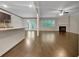 Open-concept space connecting kitchen and living room, featuring hardwood floors and a fireplace for a cozy atmosphere at 1477 Harlequin Way, Stockbridge, GA 30281