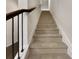 Carpeted staircase with dark wood railing leading to the upper level at 1477 Harlequin Way, Stockbridge, GA 30281