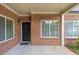 Inviting covered entryway with a classic black door, brick facade, and manicured landscaping at 2703 Brookhavenrun Cir, Duluth, GA 30097