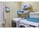 Bright laundry room with a washer, dryer, storage shelving, and a hanging towel at 2703 Brookhavenrun Cir, Duluth, GA 30097