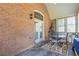 Cozy covered patio featuring brick accent wall and outdoor dining area with decorative rug at 2703 Brookhavenrun Cir, Duluth, GA 30097