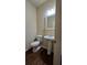 Half bathroom with pedestal sink and wood floors at 3456 Sardis Bend Dr, Buford, GA 30519