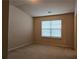 An interior view of a carpeted bedroom with neutral walls and a large window allowing natural light at 3456 Sardis Bend Dr, Buford, GA 30519