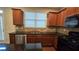 Galley kitchen featuring stainless steel appliances, granite countertops, tile backsplash, and dark wooden cabinets at 3456 Sardis Bend Dr, Buford, GA 30519