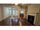 Open-concept living room with hardwood floors, a fireplace, stylish columns, and a view into the dining area at 3456 Sardis Bend Dr, Buford, GA 30519