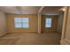 An open living room with neutral carpet, light walls, and several windows at 3456 Sardis Bend Dr, Buford, GA 30519